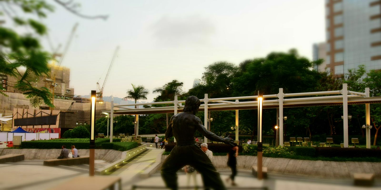 A bronze statue of Bruce Lee in a fighting pose by Hong Kong harbour