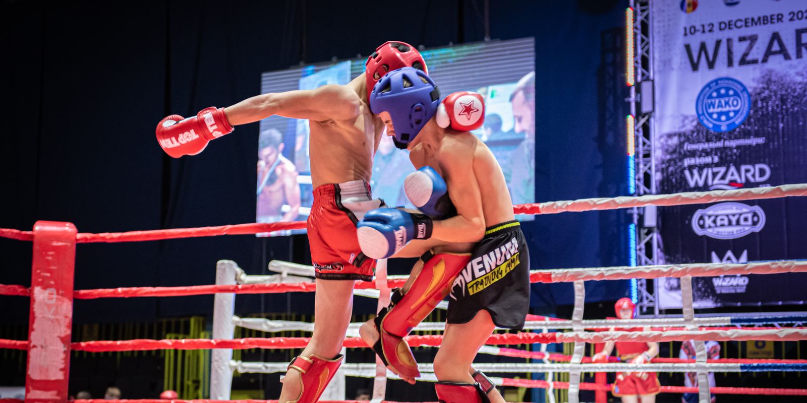 Two kickboxers exchanging kicks in a ring