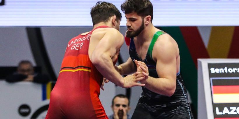 Two Greco-Roman wrestlers grappling on a mat
